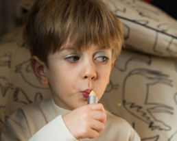 little boy applying lip balm