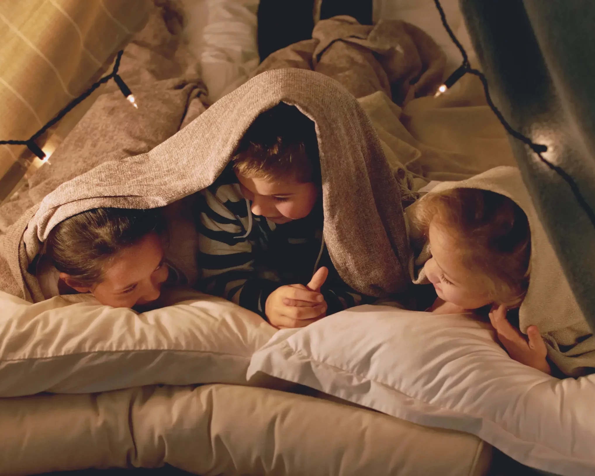 Kinder unter der Bettdecke während einer Pyjamaparty