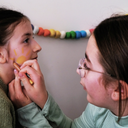 children putting make-up on each other