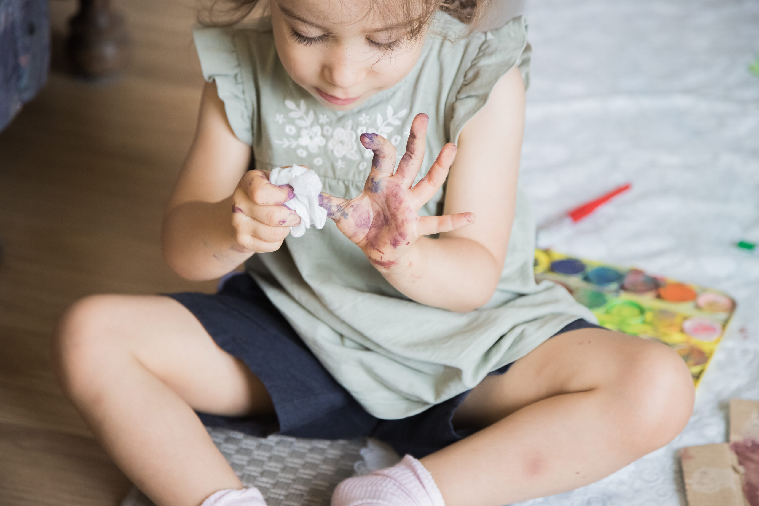 enfant qui s'essuie les doigts avec de l'essuie tout