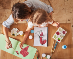 Kind, das mit seiner Mutter eine handwerkliche Tätigkeit ausübt