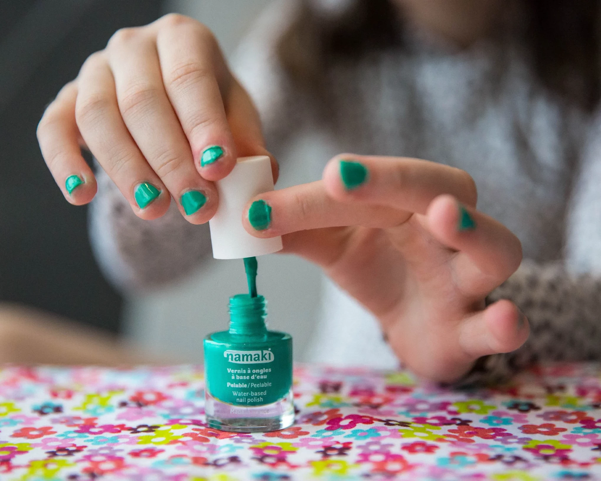 fille appliquant du vernis à ongles vert