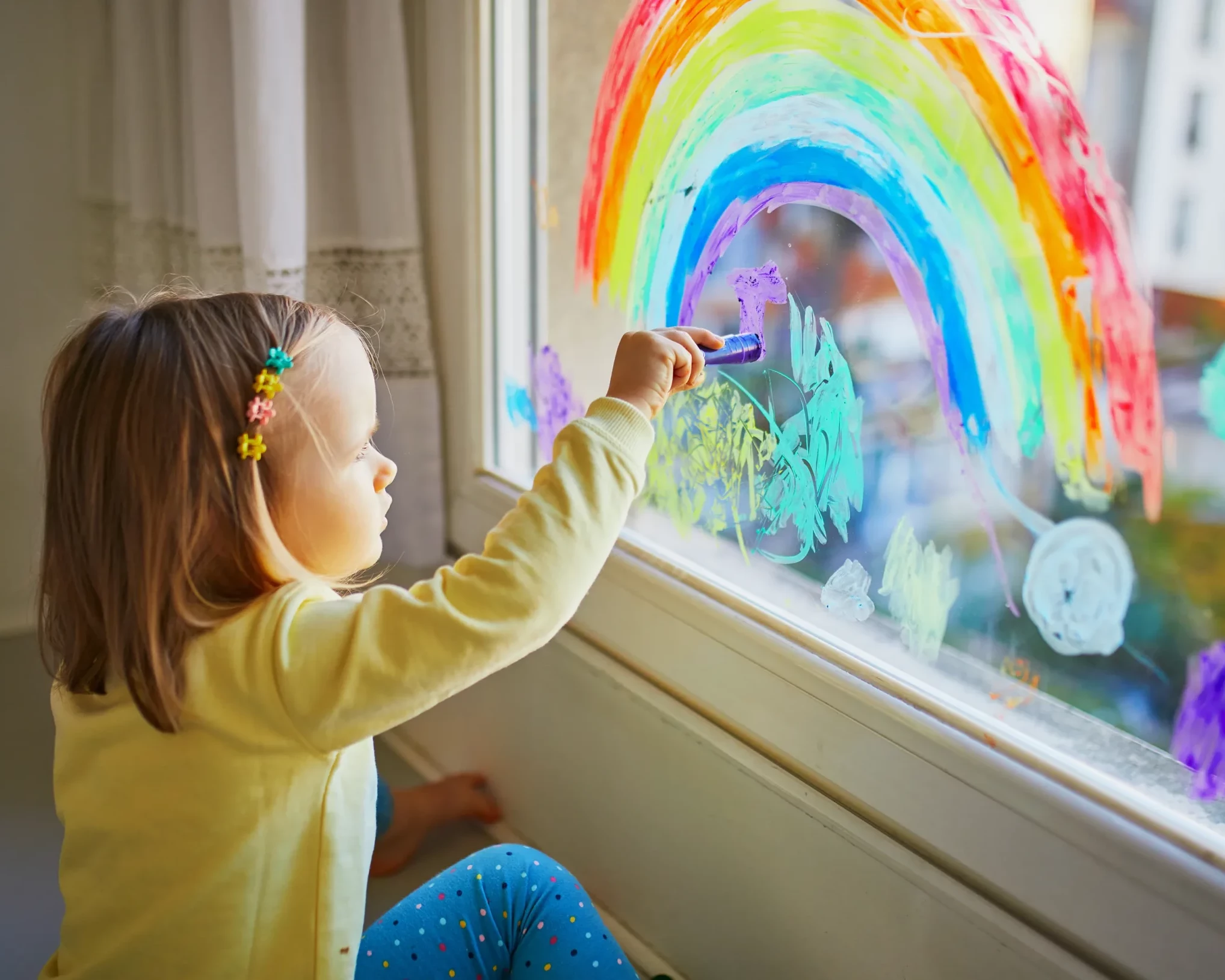 enfant qui dessine sur les vitres