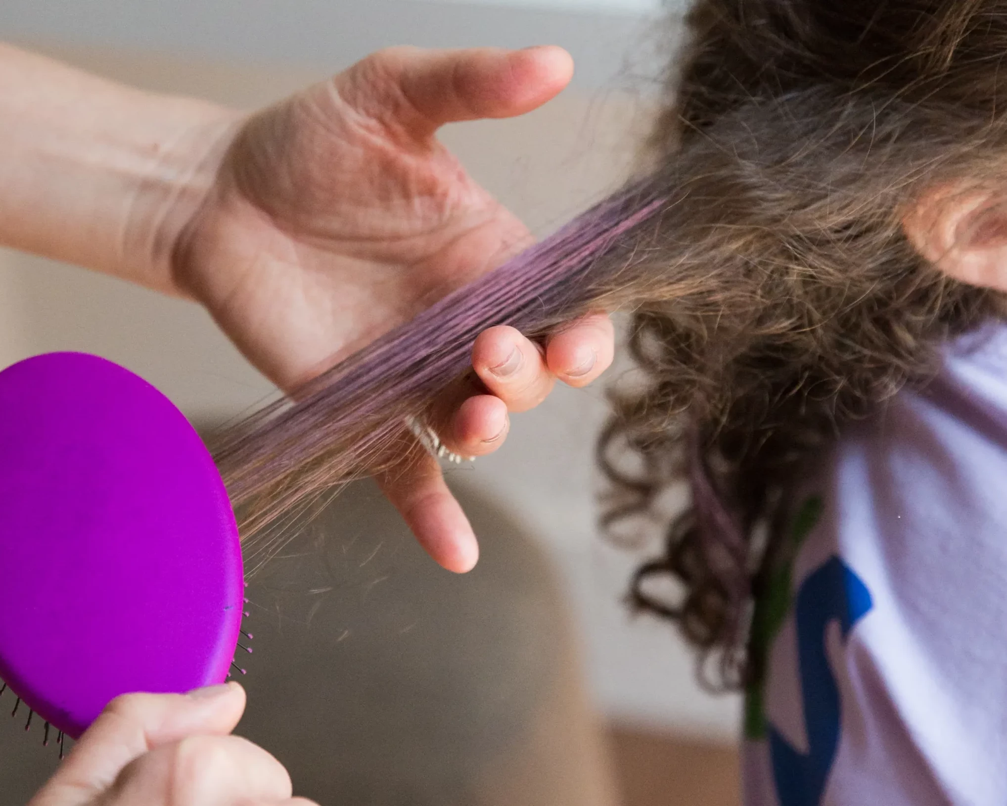 cheveux avec du mascara rose entrain d'être brossé