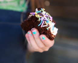 brownie tenu par des ongles vernis