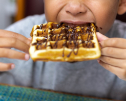 enfant en train de manger des gaufres