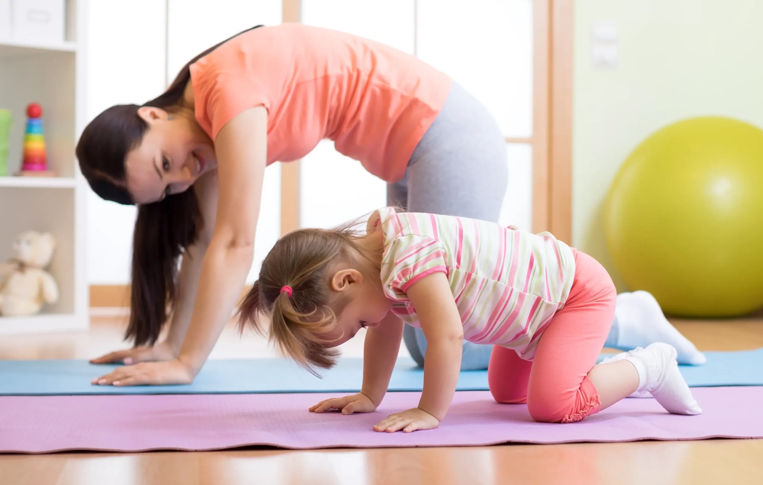Elternteil beim Yoga mit ihren Kindern